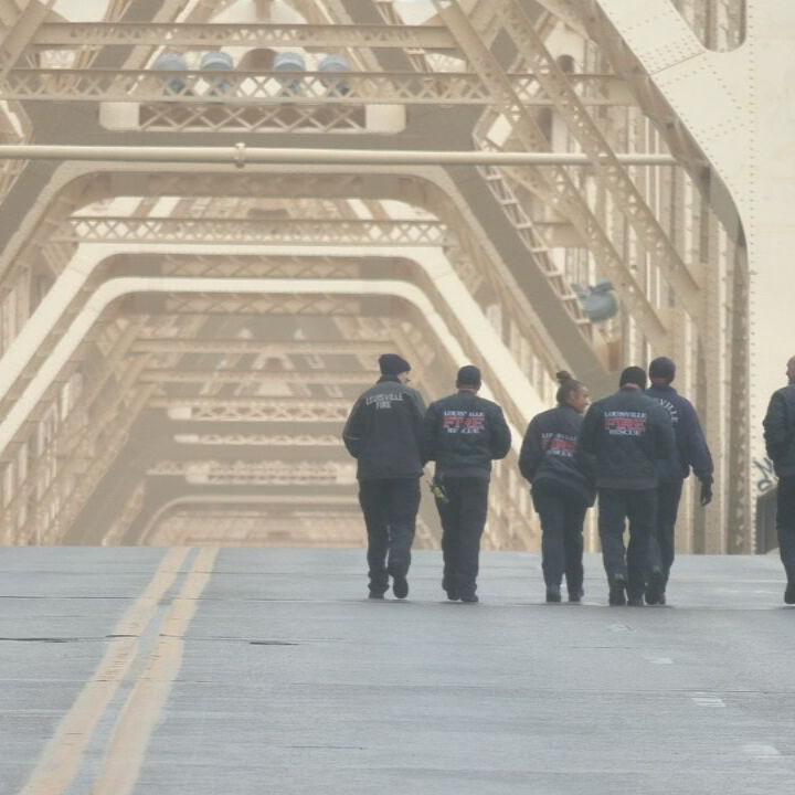 Louisville Firemen walk on 2nd Street Bridge after rescuing semi driver